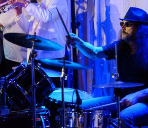 A picture of Bob Thornburgh playing the drums on stage